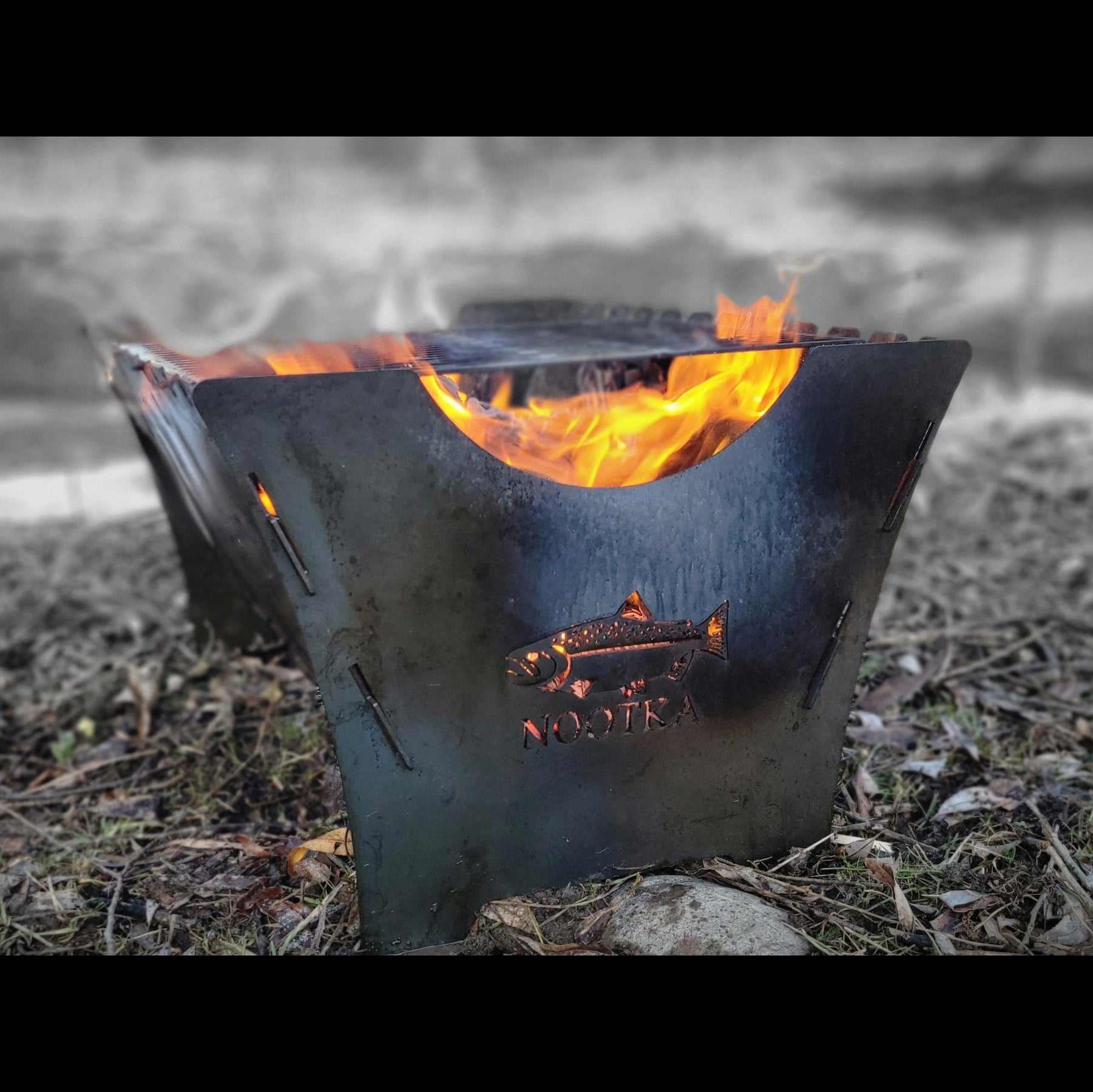 Fire pit with flames burning on a natural ground surface